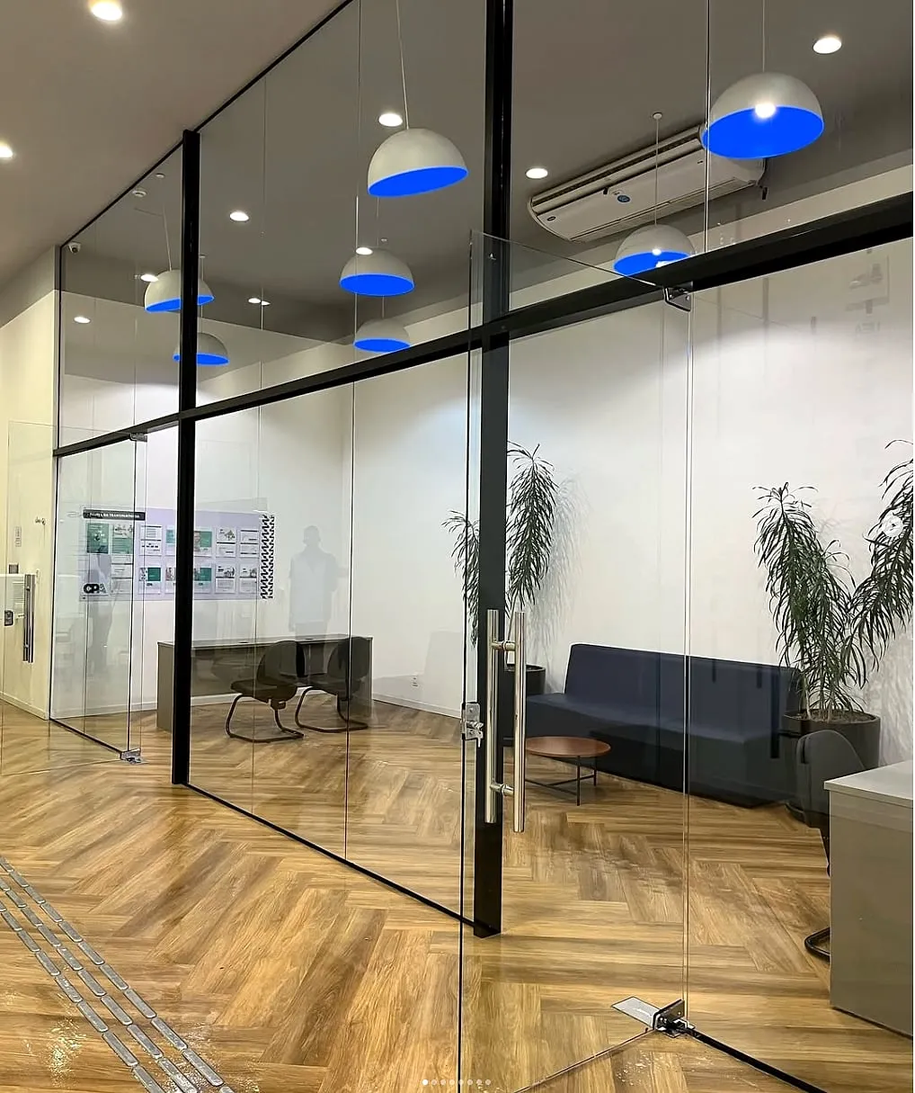 Ambiente comercial com divisória e porta de vidro — vidraçaria predial Lume Real
