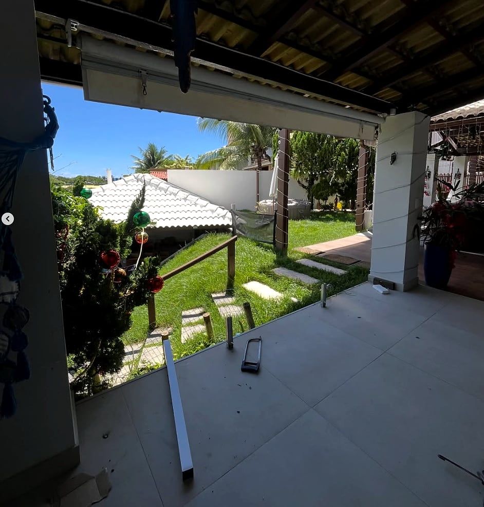 Varanda residencial antes da instalação: só os montantes metálicos fixados, sem os painéis de vidro