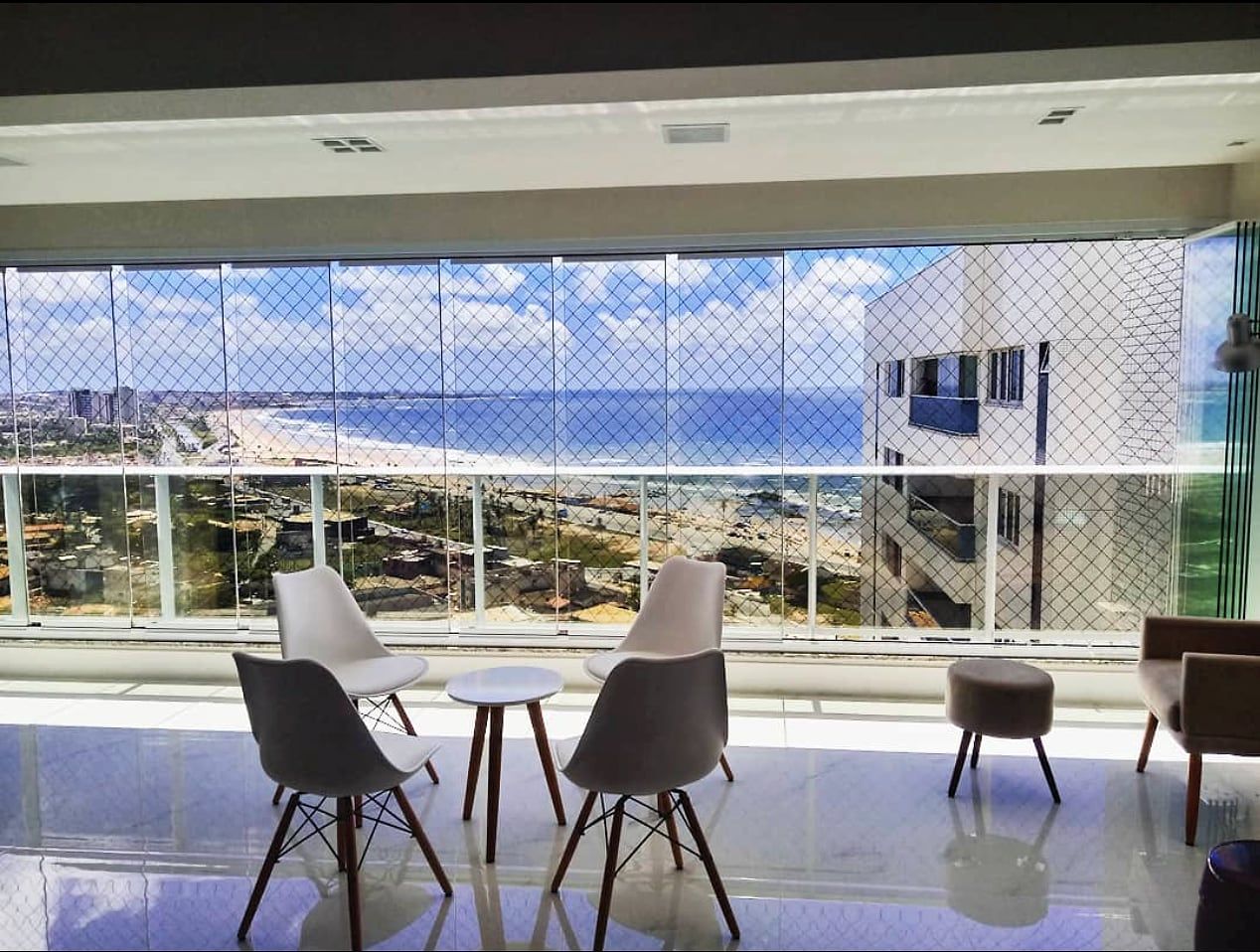 Sacada de apartamento com fechamento em vidro e rede de proteção, com vista para o mar em Salvador